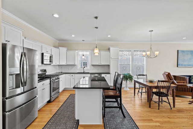 115 Webster Ln Unit 115, Middletown, CT 06457 - kitchen featuring stainless steel appliances, dark countertops, white cabinets, decorative backsplash, and crown molding