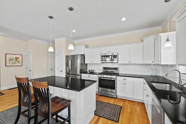 115 Webster Ln Unit 115, Middletown, CT 06457 - kitchen featuring appliances with stainless steel finishes, white cabinets, a breakfast bar area, backsplash, and ornamental molding
