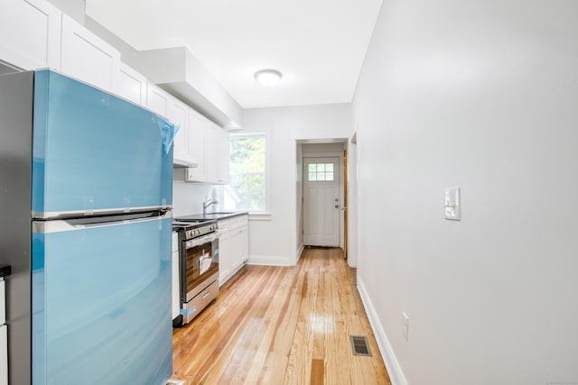 289 E Ave, Bridgeport, CT 06610 - kitchen with stainless steel appliances, white cabinetry, light wood-type flooring, and under cabinet range hood