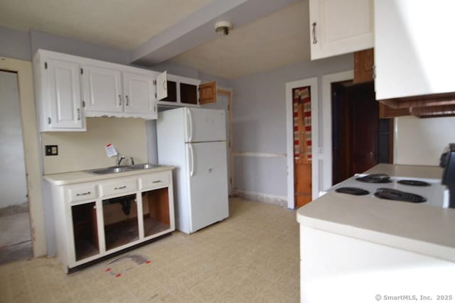 484 W St, Bristol, CT 06010 - kitchen with freestanding refrigerator, white cabinetry, light countertops, and beamed ceiling