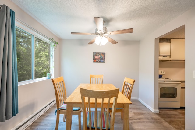 14 Newtown Rd Unit B9, Danbury, CT 06810 - dining room with a baseboard heating unit, light wood-style floors, a textured ceiling, and a ceiling fan