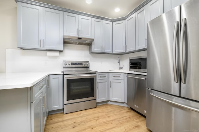 51 Old Kings Hwy Unit 5, Greenwich, CT 06897 - kitchen with stainless steel appliances, gray cabinetry, under cabinet range hood, light wood finished floors, and recessed lighting