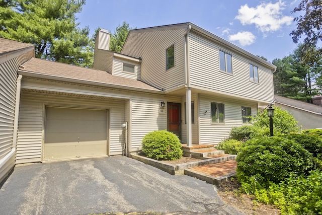 94 The Laurels Unit 94, Enfield, CT 06082 - view of front of property featuring an attached garage, a chimney, and driveway