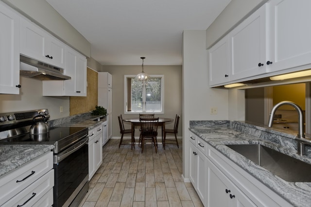 94 The Laurels Unit 94, Enfield, CT 06082 - kitchen featuring stainless steel range with electric cooktop, under cabinet range hood, white cabinets, light wood-style floors, and light stone countertops