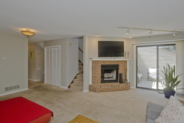 94 The Laurels Unit 94, Enfield, CT 06082 - living room with rail lighting, carpet flooring, stairway, and a fireplace