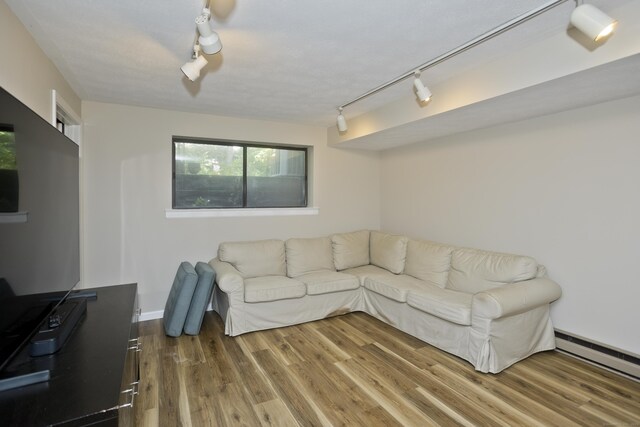 94 The Laurels Unit 94, Enfield, CT 06082 - living room featuring rail lighting, a baseboard radiator, and wood finished floors
