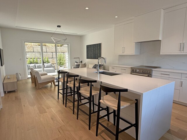 785 Post Rd E Unit 202, Westport, CT 06880 - kitchen with stainless steel stove, white cabinets, light wood-style flooring, and recessed lighting