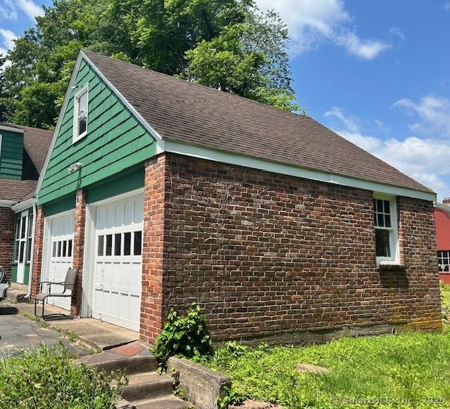 70 Tunxis Ave, Bloomfield, CT 06002 - view of side of home featuring a shingled roof, a garage, and brick siding