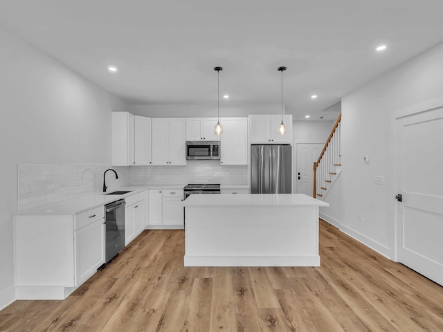 138 Boston Post Rd Unit 15, East Lyme, CT 06333 - kitchen featuring stainless steel appliances, tasteful backsplash, a kitchen island, light countertops, and white cabinets