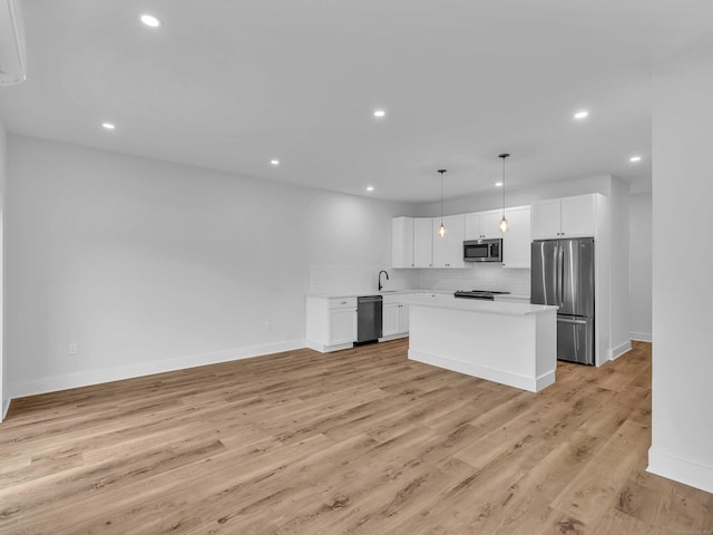 138 Boston Post Rd Unit 15, East Lyme, CT 06333 - kitchen with stainless steel appliances, tasteful backsplash, light countertops, a center island, and white cabinets