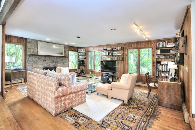 174 Cross Hwy, Westport, CT 06880 - living area featuring wooden walls, wood finished floors, track lighting, a stone fireplace, and baseboard heating