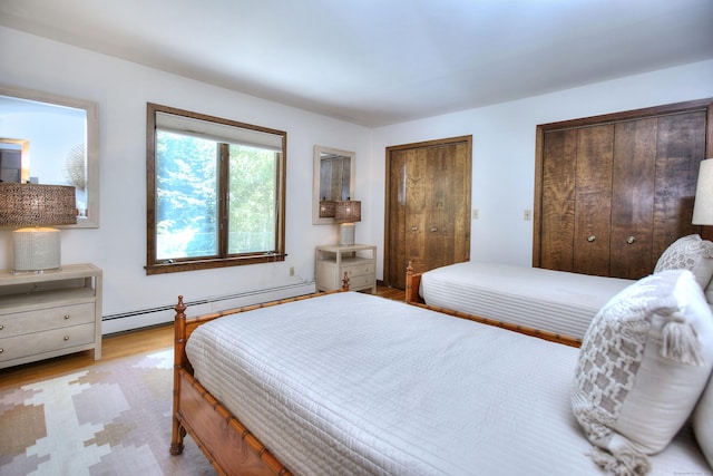 174 Cross Hwy, Westport, CT 06880 - bedroom featuring two closets, a baseboard radiator, and wood finished floors