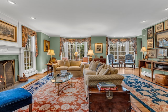 604 W Lake Ave, Guilford, CT 06437 - living room with crown molding, a warm lit fireplace, healthy amount of natural light, baseboard heating, and recessed lighting
