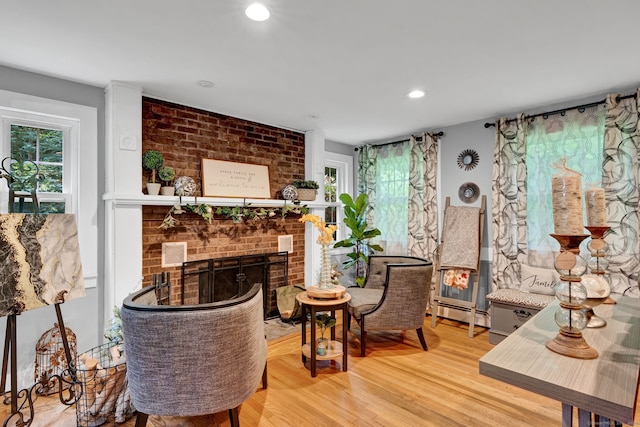 79 Ledgewood Dr, North Branford, CT 06471 - living area featuring a brick fireplace, healthy amount of natural light, wood finished floors, a baseboard radiator, and recessed lighting
