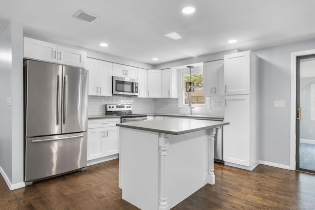 32 Cullen Ave, West Haven, CT 06516 - kitchen featuring stainless steel appliances, white cabinetry, tasteful backsplash, dark wood finished floors, and recessed lighting