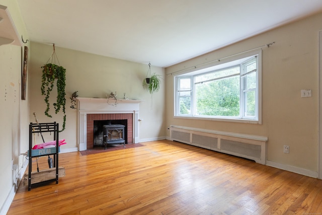 180 Lake Ave, Bristol, CT 06010 - unfurnished living room with radiator heating unit, wood finished floors, and a wood stove