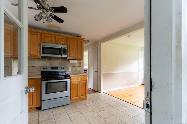 180 Lake Ave, Bristol, CT 06010 - kitchen featuring stainless steel appliances, light countertops, light tile patterned flooring, decorative backsplash, and a ceiling fan