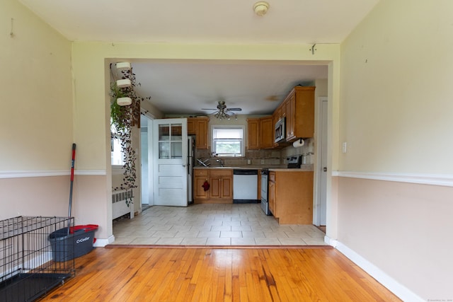 180 Lake Ave, Bristol, CT 06010 - kitchen with appliances with stainless steel finishes, light wood finished floors, brown cabinets, and decorative backsplash