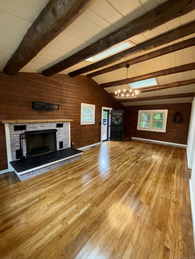 3951 S St, Coventry, CT 06238 - unfurnished living room featuring wood walls, wood finished floors, a chandelier, and a brick fireplace