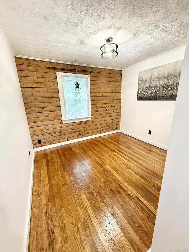 3951 S St, Coventry, CT 06238 - spare room with wooden walls, a textured ceiling, wood finished floors, and crown molding