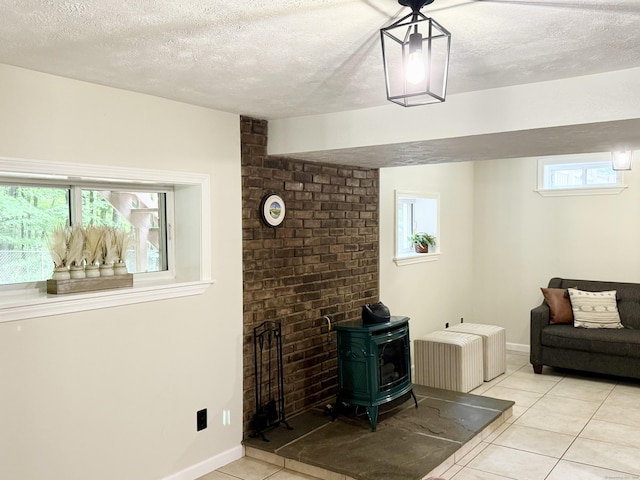 3951 S St, Coventry, CT 06238 - living room featuring a wood stove, light tile patterned floors, and a textured ceiling