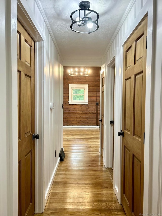 3951 S St, Coventry, CT 06238 - corridor with light wood-style floors, wood walls, a textured ceiling, and ornamental molding