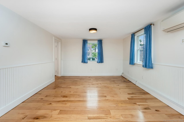 10 Sable St, Norwalk, CT 06854 - spare room with a wall unit AC, light wood finished floors, and a wainscoted wall