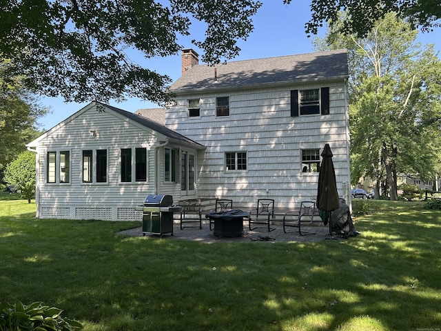 25 Tanglewood Ln, Naugatuck, CT 06770 - rear view of house featuring a chimney, a patio area, a lawn, a fire pit, and roof with shingles