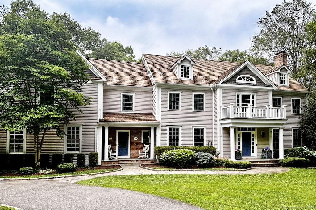 124 Princess Pine Ln, Fairfield, CT 06824 - view of front of property with a porch, a front yard, a chimney, and a balcony