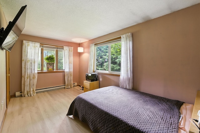 480 Wall St, Hebron, CT 06248 - bedroom with light wood-type flooring, multiple windows, a textured ceiling, and baseboard heating