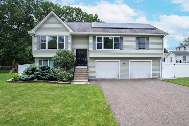 123 Sperry Ln, Meriden, CT 06451 - bi-level home featuring asphalt driveway, roof mounted solar panels, an attached garage, and roof with shingles