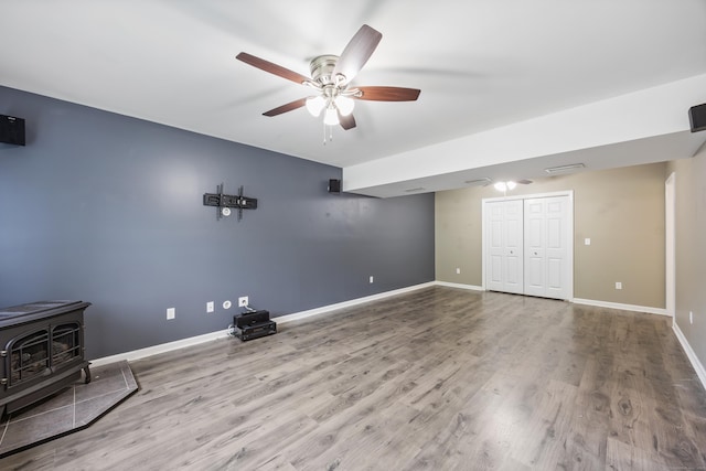 123 Sperry Ln, Meriden, CT 06451 - unfurnished living room with a wood stove, ceiling fan, and wood finished floors