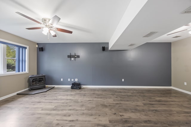 123 Sperry Ln, Meriden, CT 06451 - unfurnished room with a wood stove, a ceiling fan, and wood finished floors