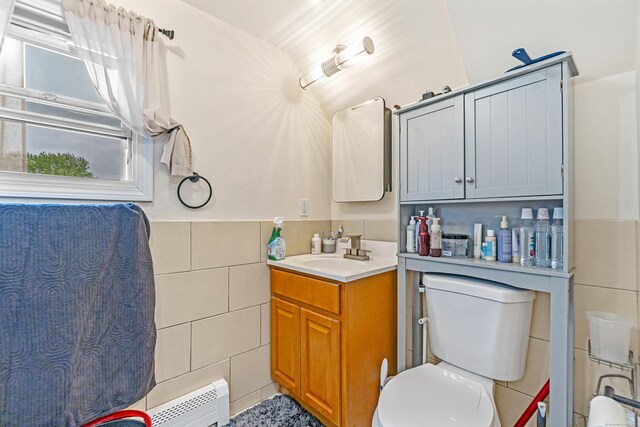 190 Whitney Ave, Bridgeport, CT 06606 - bathroom featuring tile walls, vanity, a baseboard radiator, and a wainscoted wall