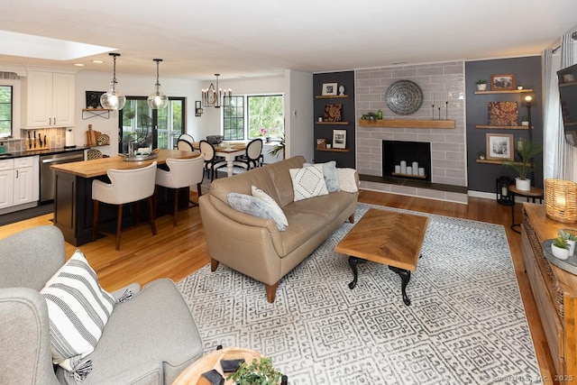 10 Laurel Grove Dr, Haddam, CT 06441 - living room with light wood finished floors, a chandelier, and a fireplace