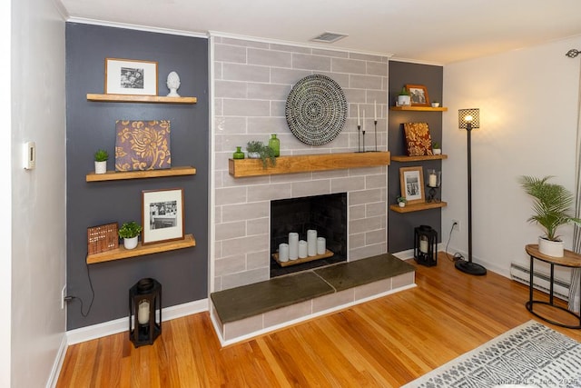 10 Laurel Grove Dr, Haddam, CT 06441 - living area featuring wood finished floors, baseboard heating, a tile fireplace, and ornamental molding