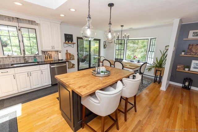 10 Laurel Grove Dr, Haddam, CT 06441 - kitchen featuring stainless steel dishwasher, butcher block counters, white cabinetry, light wood-style floors, and a kitchen breakfast bar