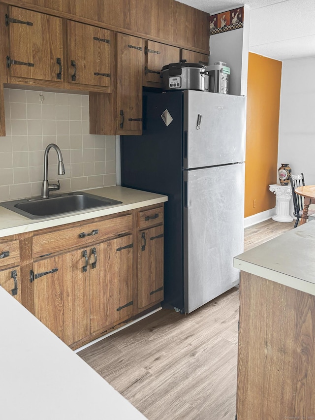 120 Huntington Tpke Unit 606, Bridgeport, CT 06610 - kitchen featuring light countertops, decorative backsplash, freestanding refrigerator, and brown cabinetry