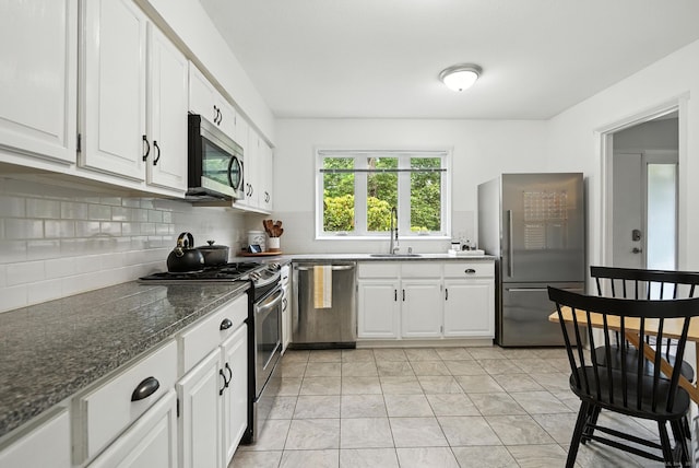 4 Earls Ct Unit 4C, Farmington, CT 06032 - kitchen featuring stainless steel appliances, decorative backsplash, white cabinets, and dark stone counters