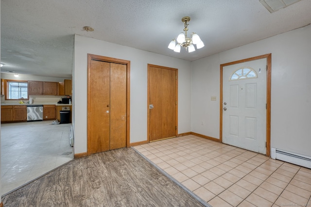 295 Hunting Lodge Rd, Mansfield, CT 06268 - foyer entrance with a chandelier, baseboard heating, light wood-style floors, and a textured ceiling