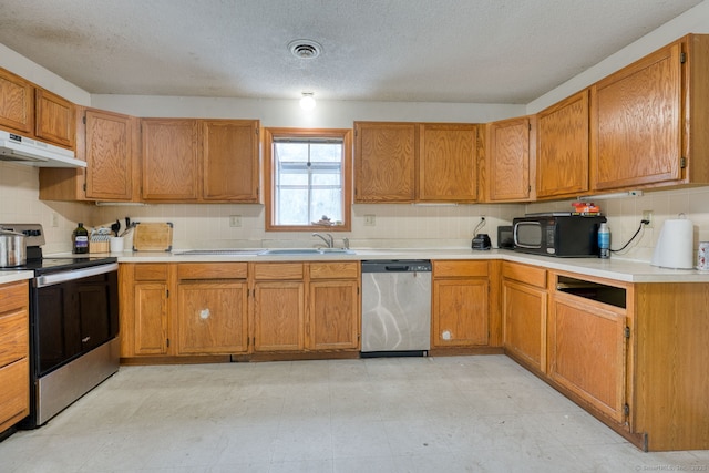 295 Hunting Lodge Rd, Mansfield, CT 06268 - kitchen featuring stainless steel appliances, under cabinet range hood, light countertops, a textured ceiling, and brown cabinets
