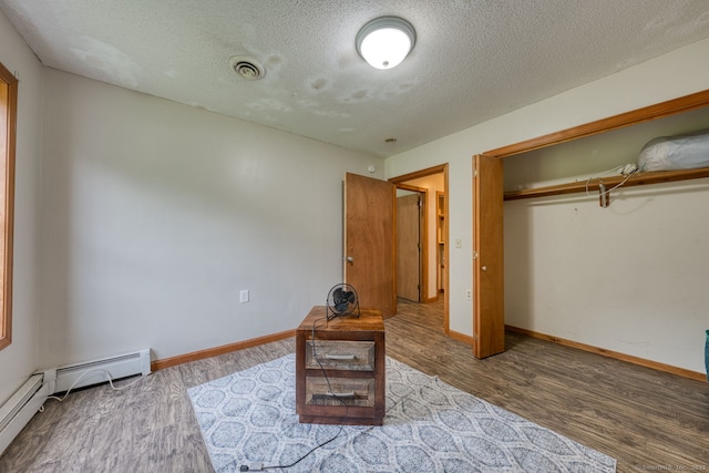 295 Hunting Lodge Rd, Mansfield, CT 06268 - bedroom featuring a textured ceiling, wood finished floors, baseboard heating, and a closet
