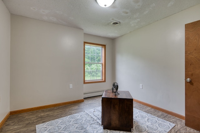 295 Hunting Lodge Rd, Mansfield, CT 06268 - spare room with a baseboard heating unit, wood finished floors, and a textured ceiling