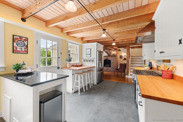 52 Aunt Park Ln, Newtown, CT 06470 - kitchen featuring wooden counters, a wood ceiling with exposed beams, white cabinets, stainless steel appliances, and wall chimney range hood