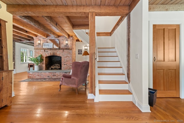 52 Aunt Park Ln, Newtown, CT 06470 - stairway featuring a wooden ceiling with exposed beams, wood-type flooring, and a brick fireplace