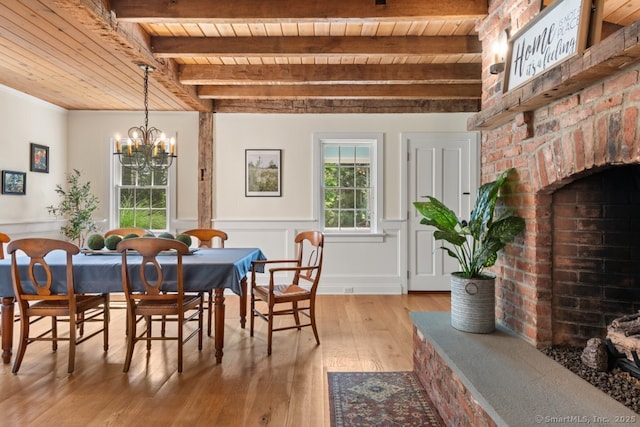 52 Aunt Park Ln, Newtown, CT 06470 - dining room featuring a wooden ceiling with exposed beams, light wood finished floors, a chandelier, wainscoting, and a brick fireplace