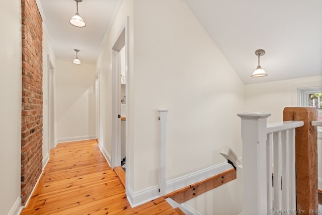 52 Aunt Park Ln, Newtown, CT 06470 - corridor with an upstairs landing, brick wall, light wood-style floors, and vaulted ceiling