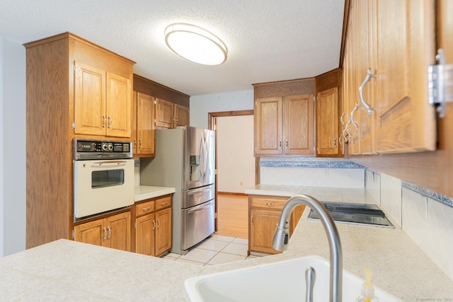 54 Timber Ln, Avon, CT 06001 - kitchen with oven, stainless steel refrigerator with ice dispenser, light countertops, black electric cooktop, and a textured ceiling