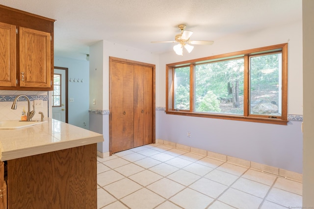 54 Timber Ln, Avon, CT 06001 - kitchen with light countertops, ceiling fan, tasteful backsplash, brown cabinets, and light tile patterned flooring