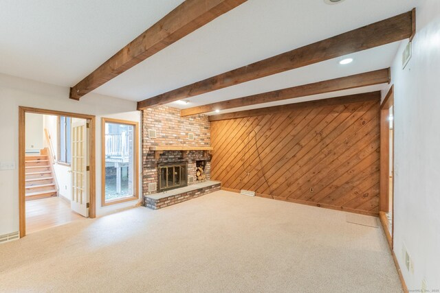 54 Timber Ln, Avon, CT 06001 - unfurnished living room with carpet flooring, beam ceiling, wood walls, a fireplace, and stairway